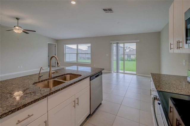 kitchen with white cabinetry, stainless steel appliances, dark stone counters, and sink