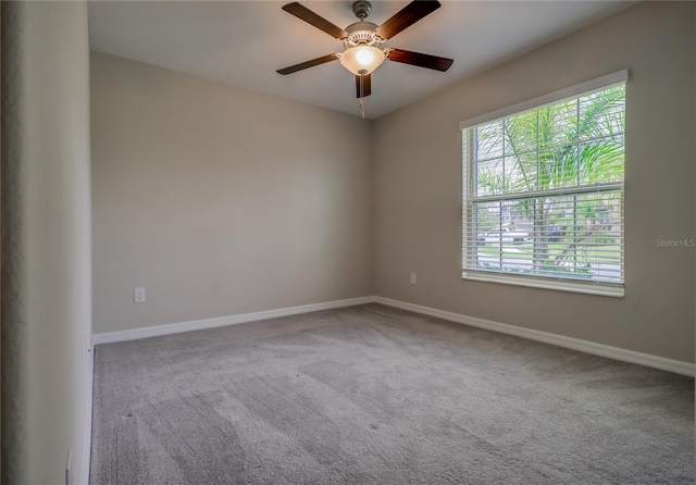 carpeted empty room featuring ceiling fan