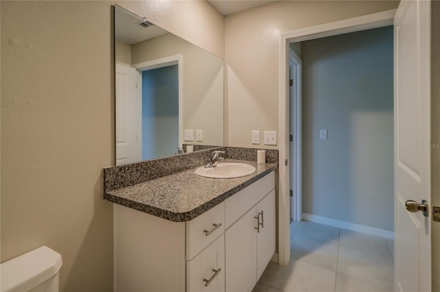 bathroom featuring vanity, toilet, and tile patterned flooring