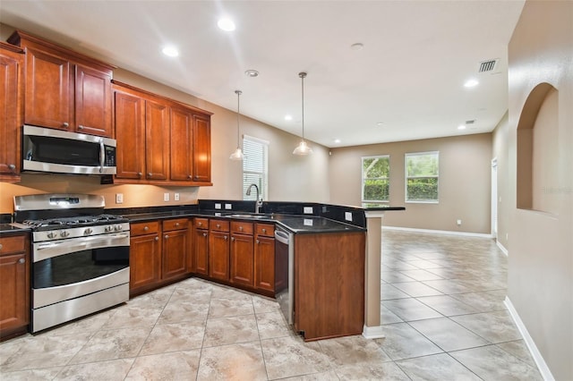 kitchen featuring decorative light fixtures, light tile patterned floors, kitchen peninsula, sink, and appliances with stainless steel finishes