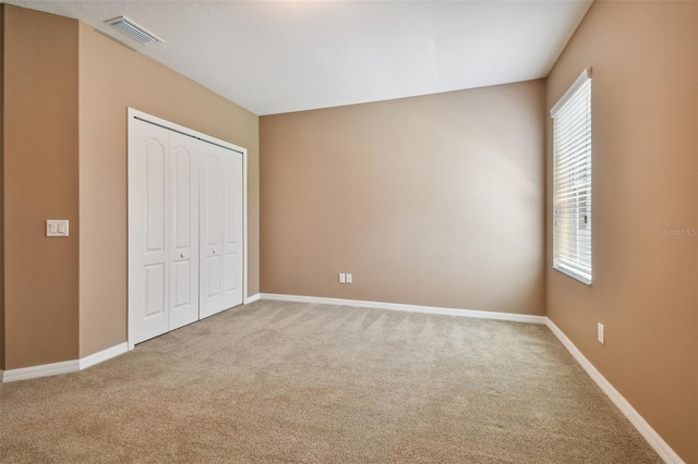 unfurnished bedroom with carpet and a closet