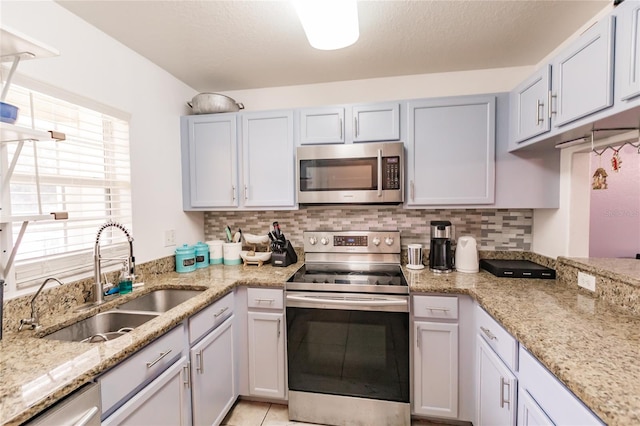 kitchen with plenty of natural light, stainless steel appliances, sink, and backsplash