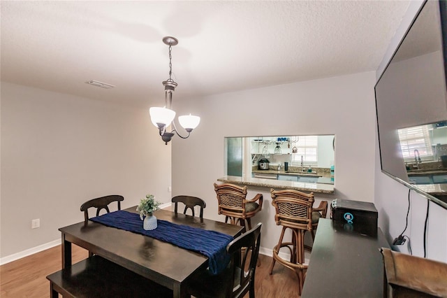 dining room with wood-type flooring and a notable chandelier