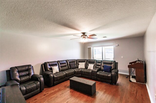 living room featuring a textured ceiling, ceiling fan, and dark hardwood / wood-style floors