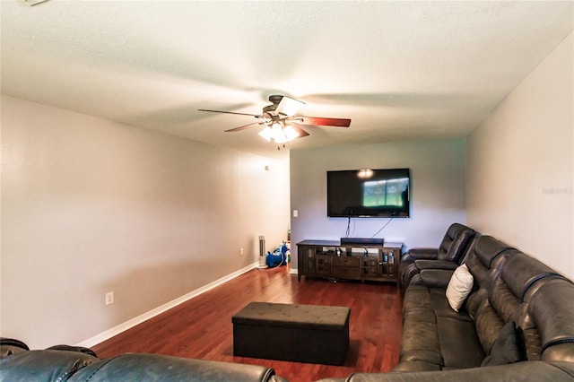 living room featuring dark wood-type flooring and ceiling fan