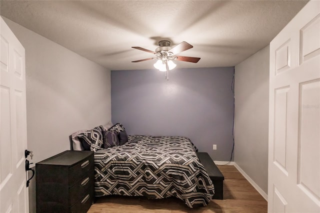 bedroom featuring a textured ceiling, wood-type flooring, and ceiling fan