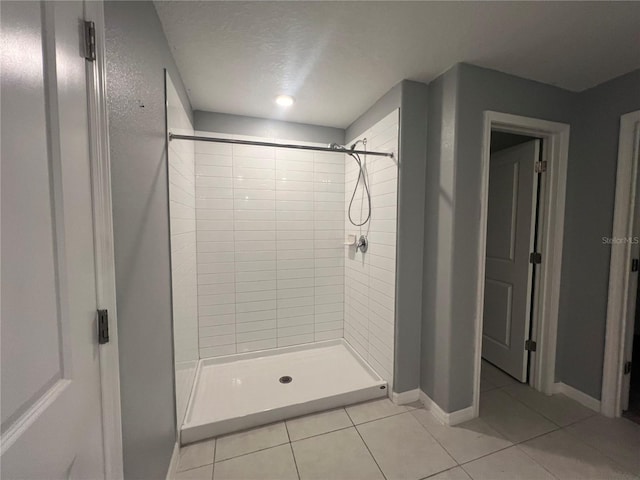 bathroom with tile patterned floors, tiled shower, and a textured ceiling