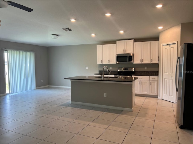 kitchen with sink, white cabinetry, stainless steel appliances, and an island with sink