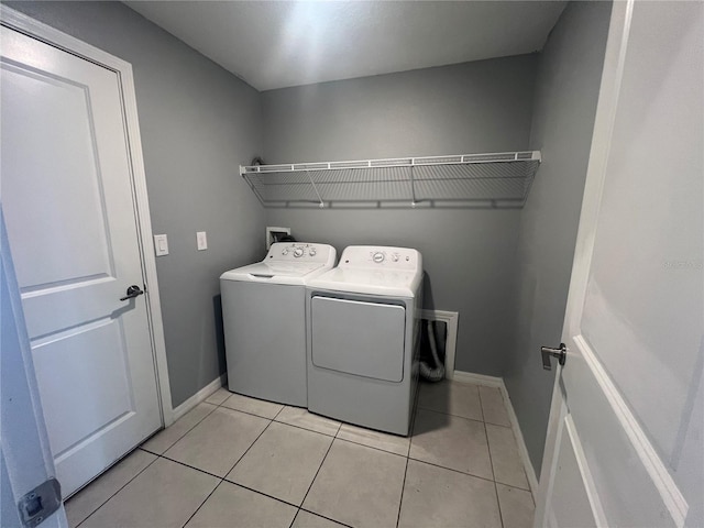 washroom with washer and dryer and light tile patterned flooring