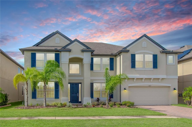 view of front of property with a garage and a yard