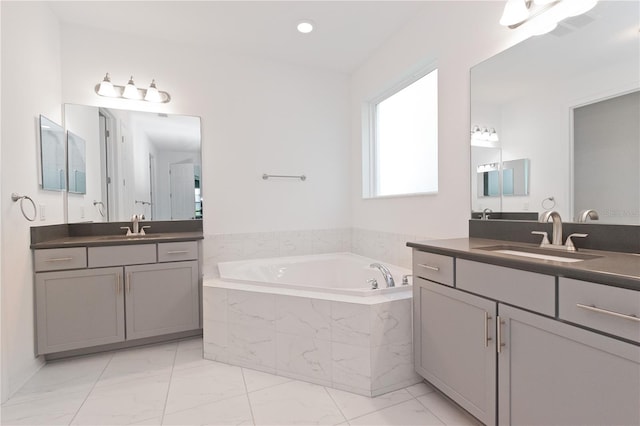 bathroom featuring vanity and tiled bath