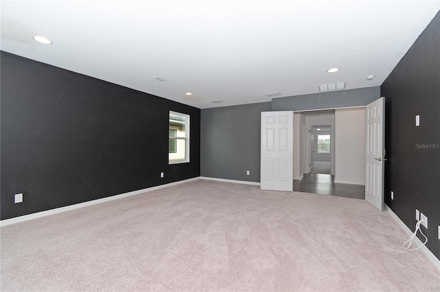 unfurnished room featuring light colored carpet and a wealth of natural light