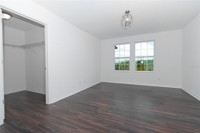 interior space with a walk in closet, a closet, and dark hardwood / wood-style flooring