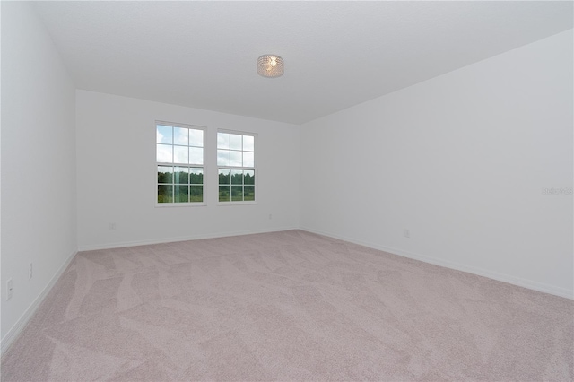 unfurnished room featuring light carpet