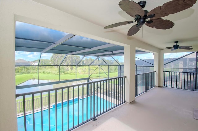 view of swimming pool with ceiling fan, a patio area, and a lanai