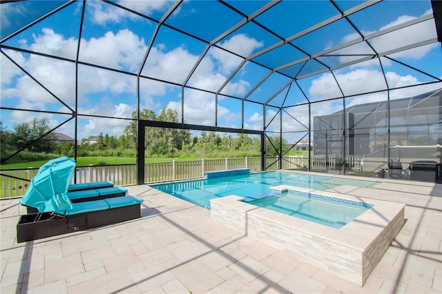 view of pool featuring an in ground hot tub, glass enclosure, a patio area, and a water view