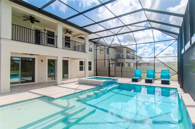 view of pool with ceiling fan, a patio, glass enclosure, and an in ground hot tub