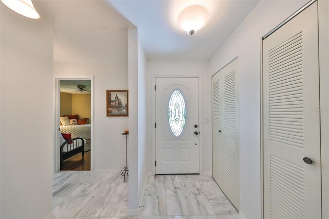 foyer entrance featuring ceiling fan