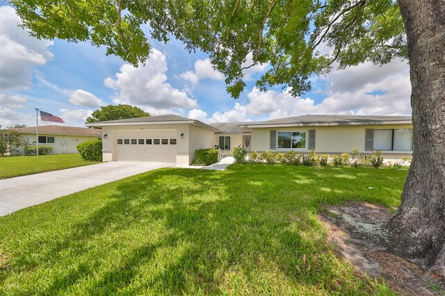 ranch-style home with a garage and a front lawn