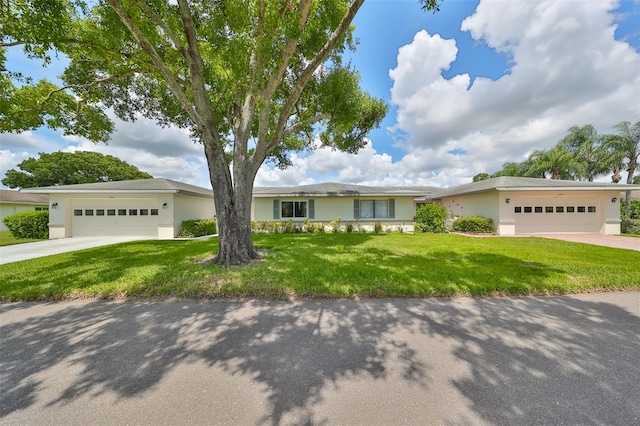 single story home with a garage and a front lawn