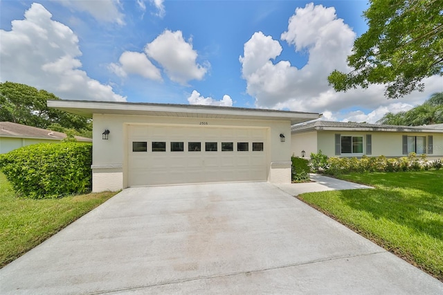 single story home featuring a garage and a front lawn