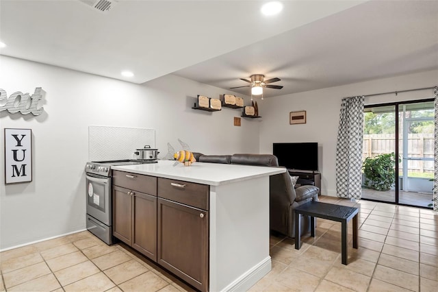 kitchen with stainless steel range with electric cooktop, light tile patterned floors, ceiling fan, and dark brown cabinetry