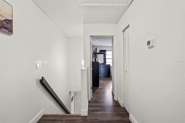 corridor featuring a textured ceiling and dark wood-type flooring