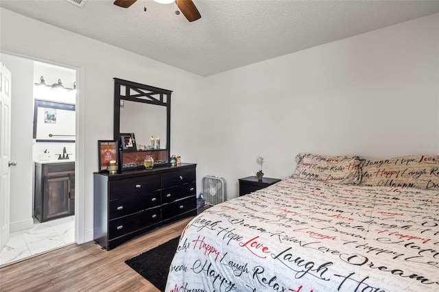 bedroom featuring light wood-type flooring, ceiling fan, and a textured ceiling