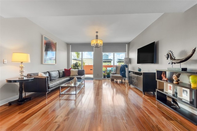 living room with wood-type flooring and an inviting chandelier