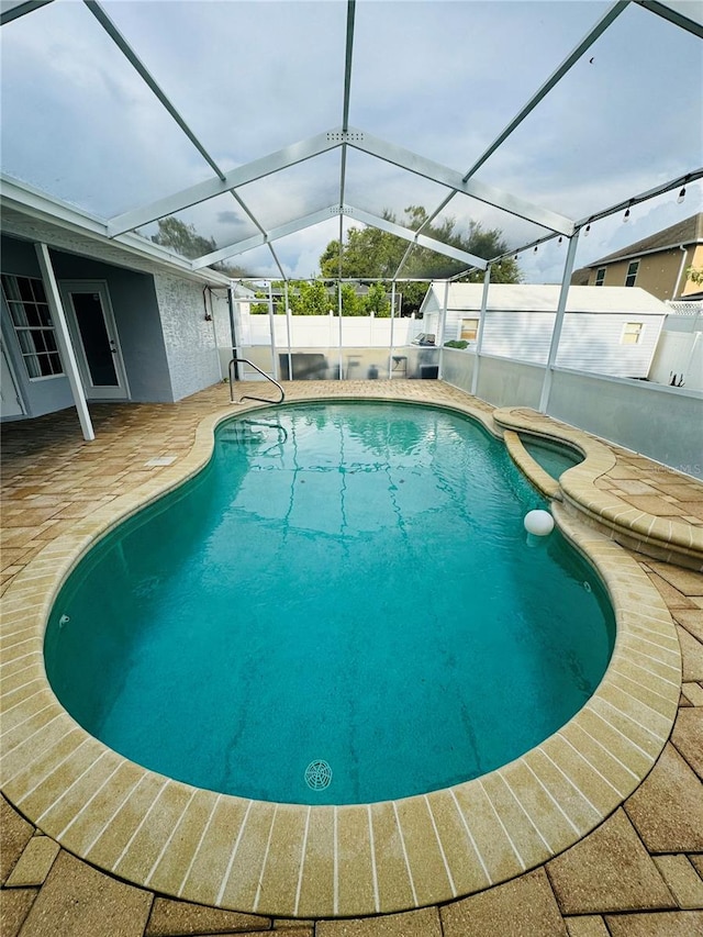 view of swimming pool with a lanai and a patio