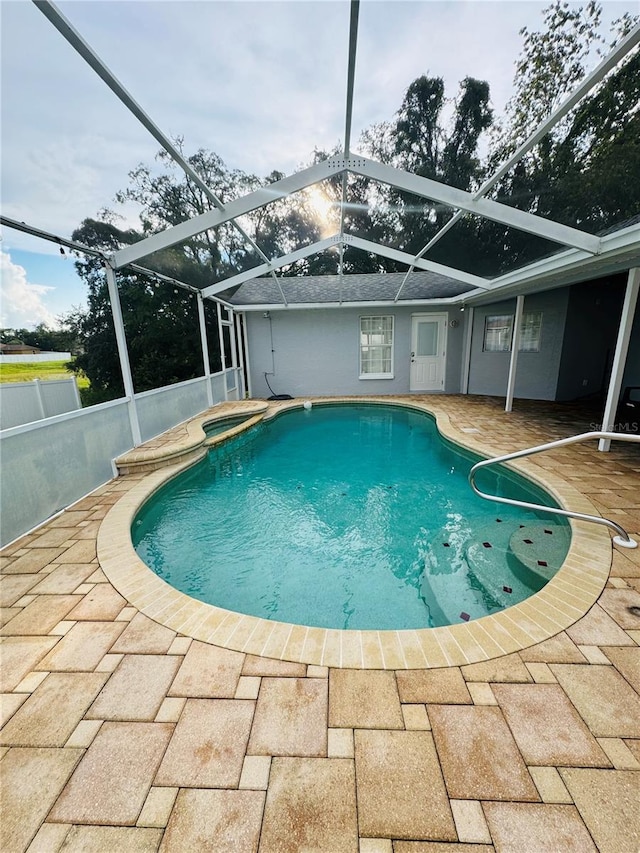 view of swimming pool with glass enclosure and a patio area