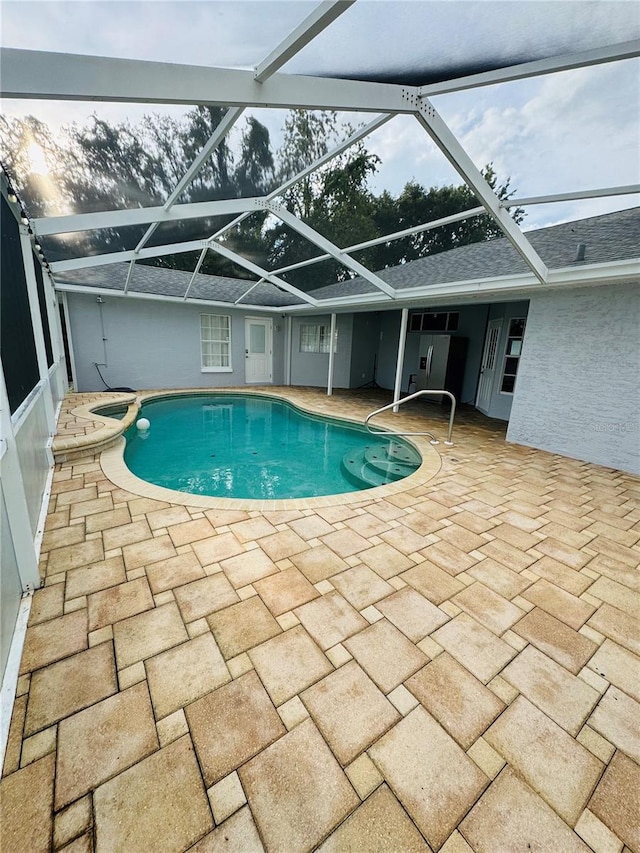 view of pool with a patio and glass enclosure