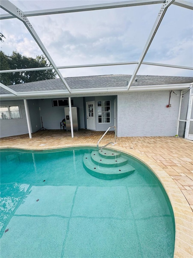 view of swimming pool with a lanai and a patio area