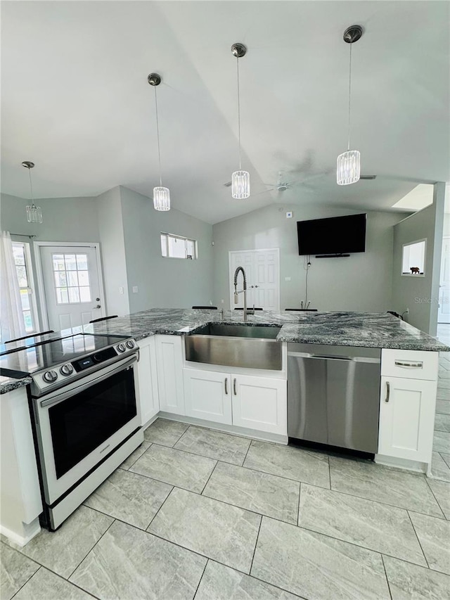 kitchen featuring pendant lighting, white cabinetry, stainless steel appliances, sink, and lofted ceiling