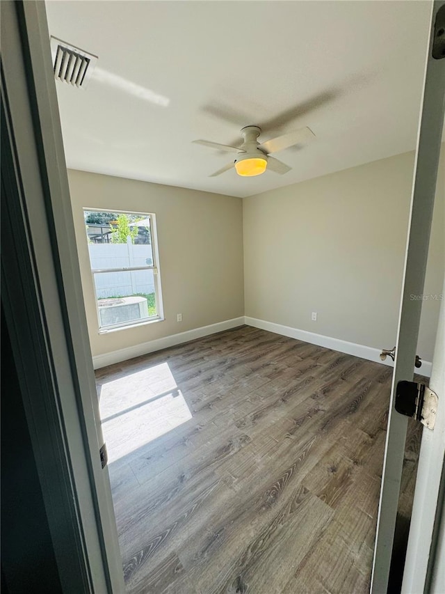 empty room with hardwood / wood-style flooring and ceiling fan