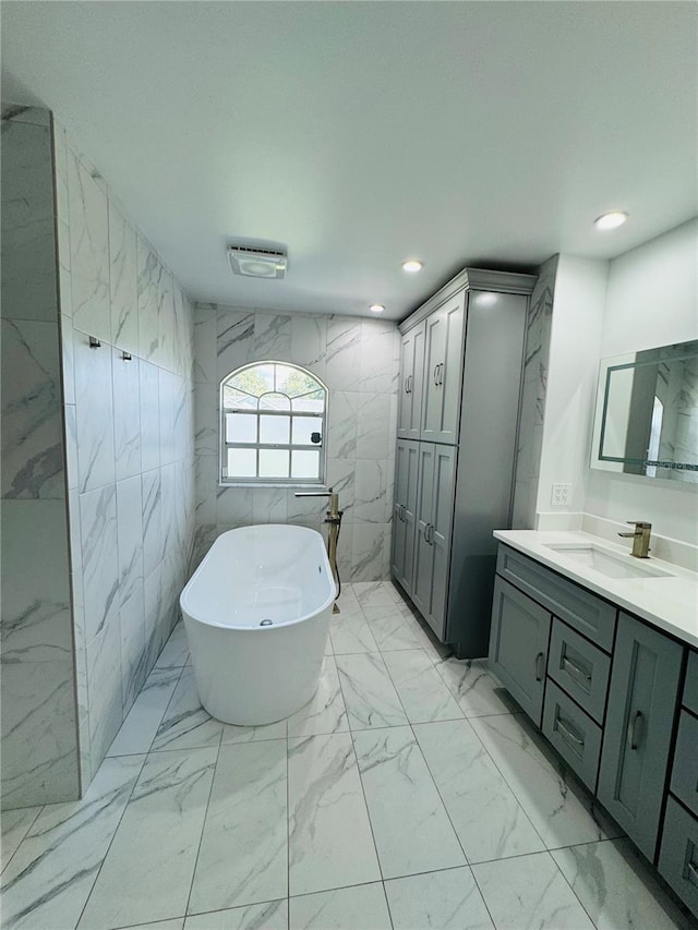 bathroom featuring vanity, tile walls, and a washtub