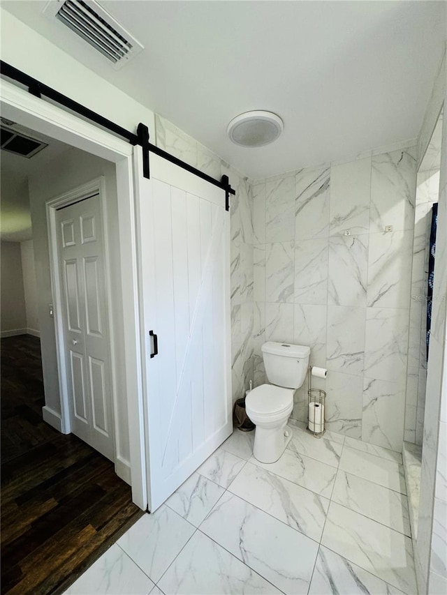 bathroom featuring tile walls, toilet, and a tile shower