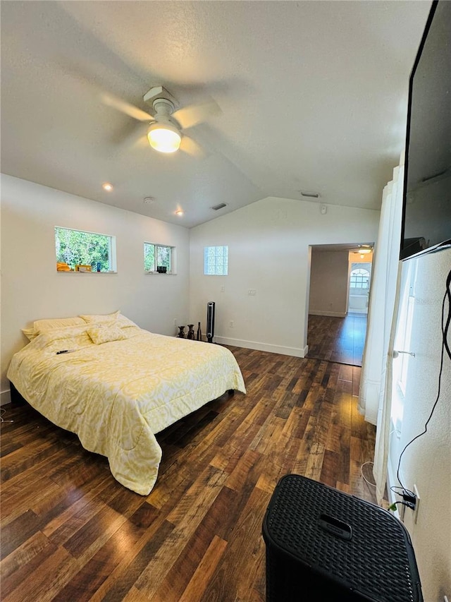 bedroom featuring dark wood-type flooring, vaulted ceiling, and ceiling fan