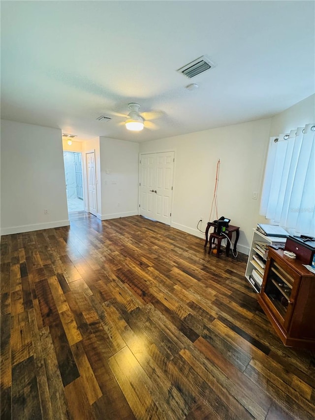 interior space featuring dark wood-type flooring and ceiling fan