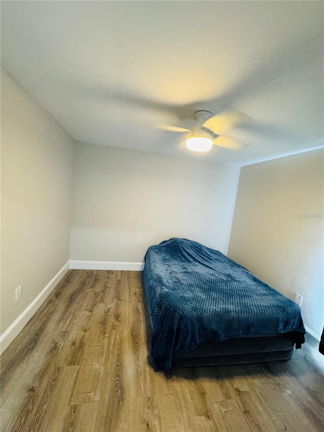 bedroom featuring a textured ceiling, ceiling fan, and wood-type flooring