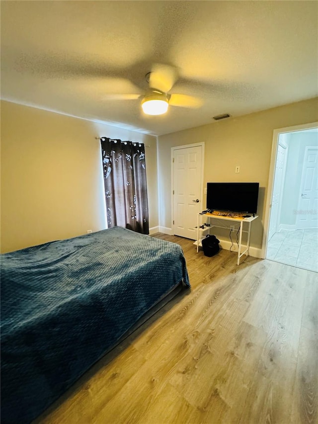 bedroom featuring wood-type flooring, a textured ceiling, and ceiling fan