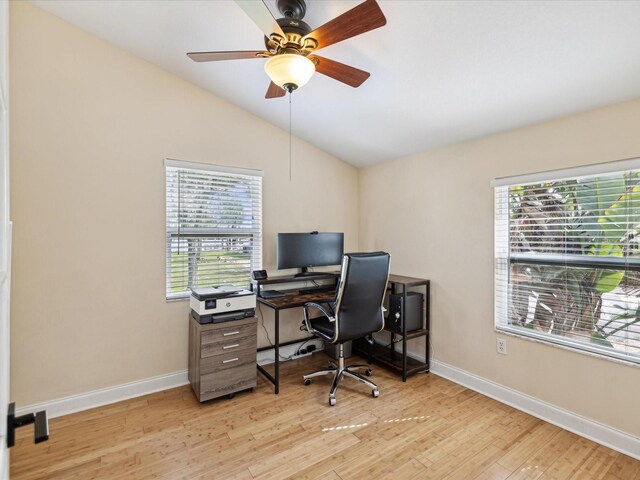 office space with ceiling fan, vaulted ceiling, light wood-type flooring, and a healthy amount of sunlight