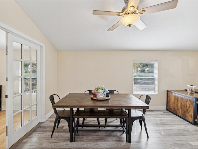 dining space featuring lofted ceiling, ceiling fan, and light hardwood / wood-style flooring