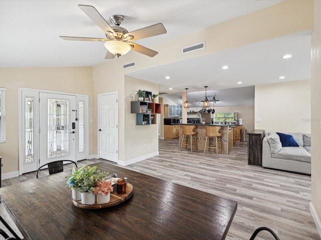 dining area with lofted ceiling, light hardwood / wood-style flooring, and ceiling fan