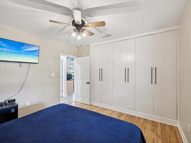 unfurnished bedroom featuring ceiling fan, light hardwood / wood-style flooring, and a closet