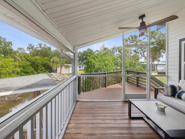 wooden terrace with a water view and ceiling fan