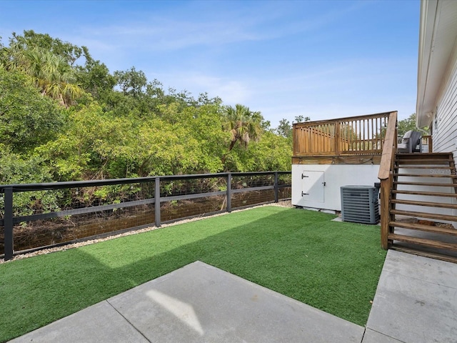 view of yard featuring a deck and central air condition unit