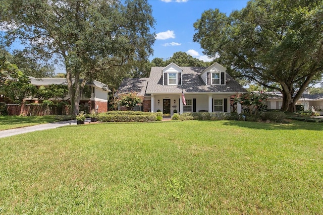 cape cod home with a front lawn