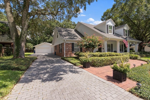 view of side of home featuring a detached garage, an outdoor structure, and brick siding