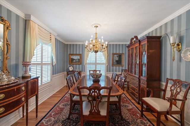 dining space featuring hardwood / wood-style flooring, a chandelier, and crown molding